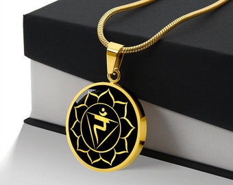 May include: Gold necklace with a black pendant featuring a gold symbol and a gold flower design. The pendant is round and has a shiny finish.