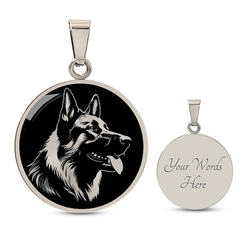 May include: A silver pendant with a black and white silhouette of a German Shepherd dog on one side and a blank space for engraving on the other side. The pendant is round and has a silver chain.