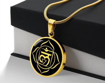 May include: Gold necklace with a black circular pendant featuring a gold symbol and design. The symbol is a stylized representation of the Anahata chakra, the heart chakra.
