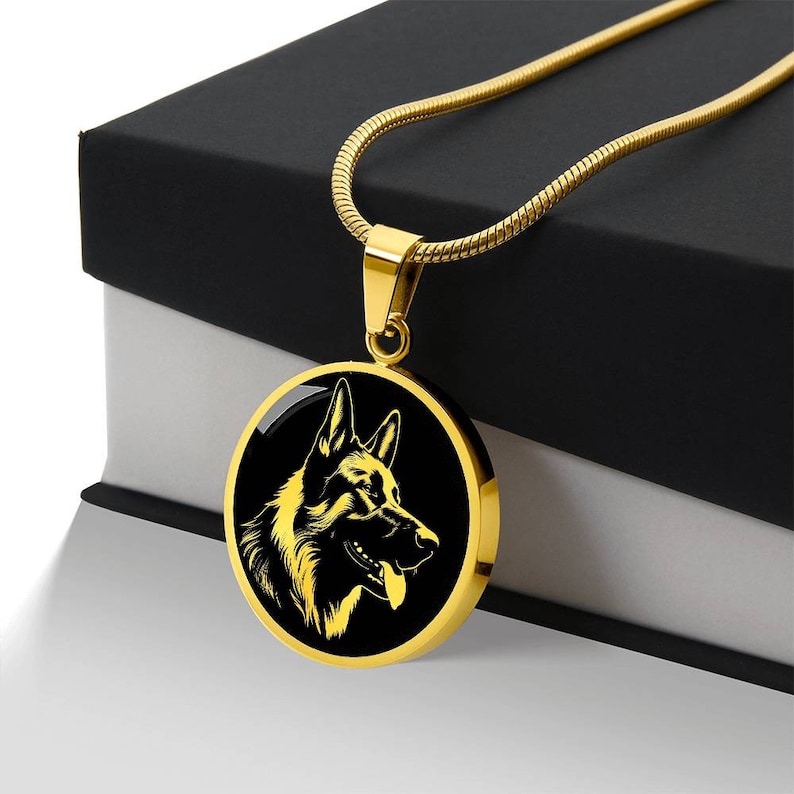 May include: A gold chain necklace with a round pendant featuring a black silhouette of a German Shepherd dog's head.