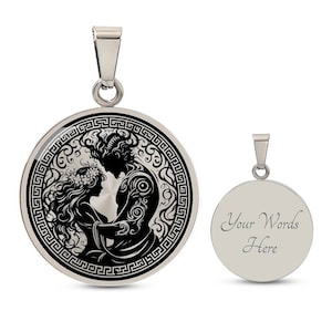 May include: A silver pendant necklace with a round, black and white image of a couple embracing. The image is surrounded by a Greek key border. The back of the pendant is plain silver with the text "Your Words Here".