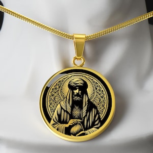 Può includere: Collana con pendente dorato con un'illustrazione dettagliata di una figura in abito, con barba e turbante. Il pendente ha uno sfondo nero con filigrana dorata e una cornice dorata, sospeso a una catena dorata.