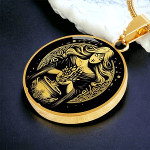 May include: Gold pendant necklace with a black circular charm featuring a detailed illustration of a woman holding a bowl of wheat. The woman is surrounded by a Celtic knot design.