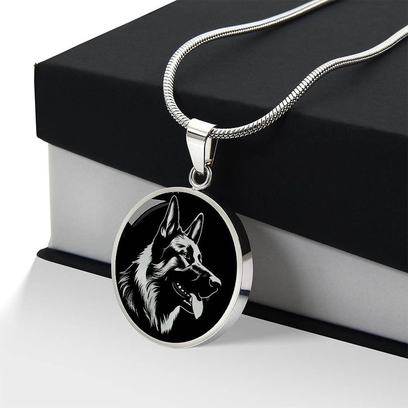 May include: A silver chain necklace with a round pendant featuring a black and white silhouette of a German Shepherd dog's head.