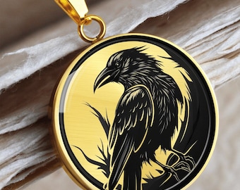 May include: A gold necklace with a round pendant featuring a black silhouette of a crow on a gold background.