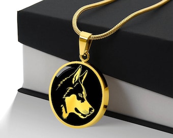 Può includere: Una collana con catena dorata con un ciondolo rotondo che presenta una silhouette nera di una testa di lupo.