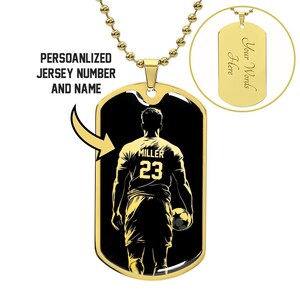 Op de afbeelding: Gouden hondenpenning ketting met een zwart en gouden afbeelding van een voetballer met de naam "Miller" en het nummer "23" op de achterkant. De voorkant van de penning zegt "Uw woorden hier".
