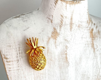 Broche llamativo vintage en tono dorado con diseño de piña y frutas tropicales.