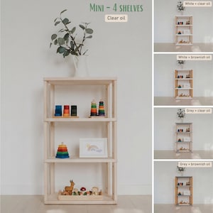 May include: A four-shelf wooden bookcase with a natural finish. The shelves display colorful wooden toys, a framed picture, and decorative items. The text "MINI - 4 SHELVES" and "Clear oil" are visible at the top. The bookcase is designed for storage and display.