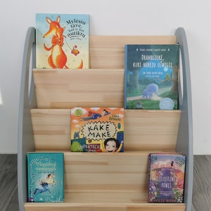 The Montessori bookshelf is shown here from the front. The sides are painted light grey, the middle parts are oiled with clear oil. Size of the Montessori storage: Height 66, Width 64, Depth 42 cm.