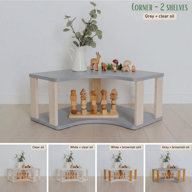 May include: A gray corner shelf unit with two levels and light-colored wooden legs. The top shelf holds a white pitcher with greenery and wooden toys. The text "CORNER - 2 SHELVES" and "Grey + clear oil" is visible.