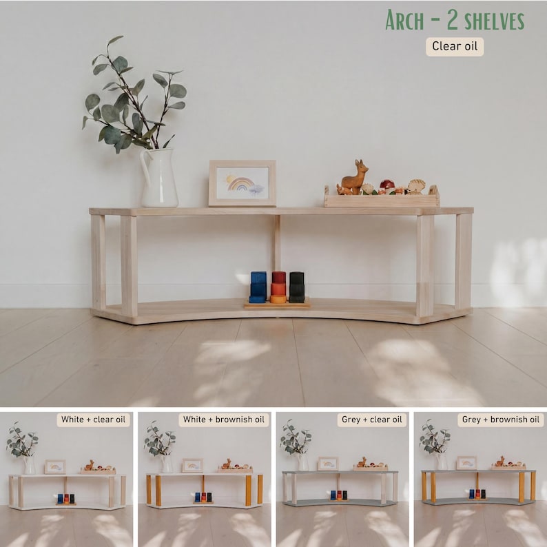 May include: A light-colored wooden shelf unit with two shelves and a curved bottom. The text "ARCH - 2 SHELVES" and "Clear oil" are visible. The shelf is displayed with decorative items, including a framed picture and a vase.
