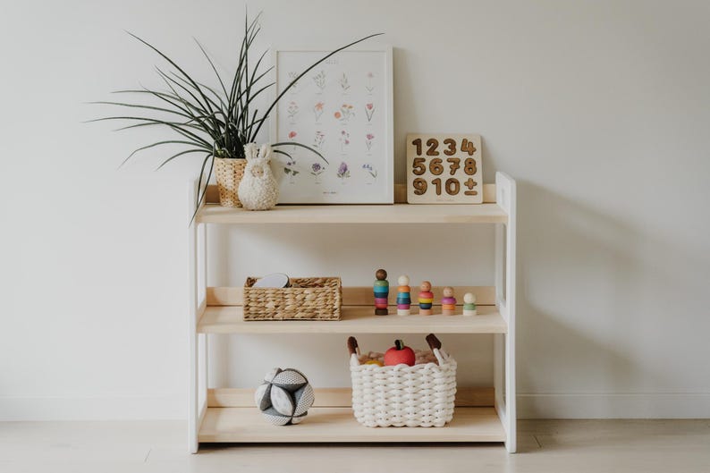 Scandinavian-style open, 3-shelf, solid wood Montessori shelf. The sides are painted white, the middle shelves are light wood, oiled with clear oil. Perfectly compatible with our Montessori bookshelves - same height and depth.