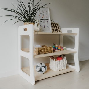 Scandinavian-style open, 3-shelf, solid wood Montessori shelf. The sides are painted white, the middle shelves are light wood, oiled with clear oil. Perfectly compatible with our Montessori bookshelves - same height and depth.