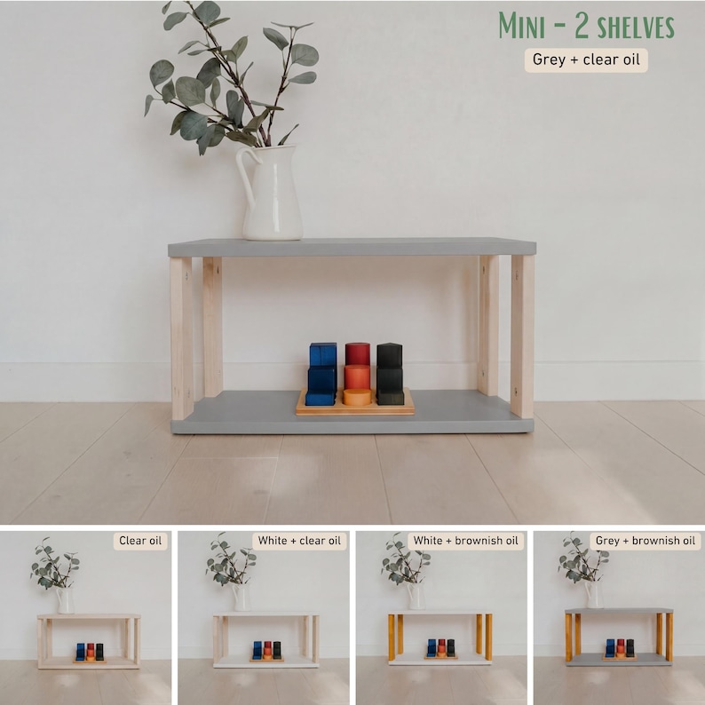 May include: A small, two-shelf wooden unit with a gray top and natural wood legs. The unit is holding a set of colorful wooden blocks. The text "MINI - 2 SHELVES" and "Grey + clear oil" is visible.