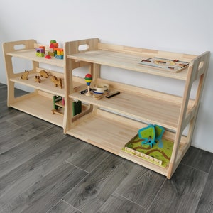 The Montessori shelves in two sizes are shown here. On the left is a smaller one with the following dimensions:Height 57, width 71, depth: 37 cm. On the right is a larger Montessori shelf measuring: Height 66, width 81, depth 42 cm.