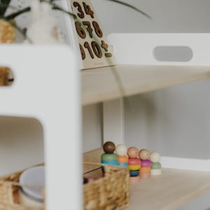 The Montessori shelf is pictured close-up to show the perfect quality, the rounded corners, and the beautiful structure of natural wood
