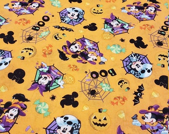 May include: Orange fabric with a Halloween themed print featuring Mickey Mouse and Minnie Mouse dressed in witch costumes. The print also includes pumpkins, bats, candy, and spiderwebs. The text "BOO" is repeated throughout the print.