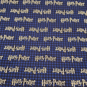 Op de afbeelding: Blauw en zwart stof met een herhalend patroon van de woorden "Harry Potter" en "Jallod 4iEH" in een wit lettertype.