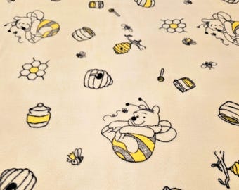 Tela polar de Winnie the Pooh, fondo color canela, precio por corte a medida, 60" de ancho.