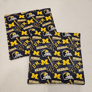 Op de afbeelding: Een witte keramische mok met een zwart handvat en de tekst "But First, Coffee" in een vetgedrukte, zwarte letter. De mok staat tegen een vage achtergrond, wat een gezellige setting suggereert.