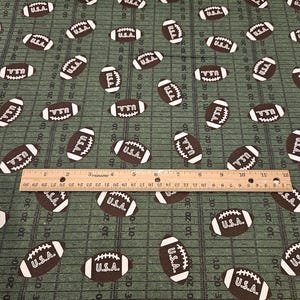 Footballs on field FLANNEL fabric; last 31" piece