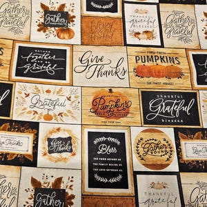 Peut inclure: Un tissu à motifs avec des panneaux sur le thème de l'automne. Les panneaux présentent des citrouilles, des feuilles d'automne et des phrases comme "Gather & Grateful", "Give Thanks" et "Farm Fresh Pumpkins". La palette de couleurs comprend l'orange, le marron et la crème.