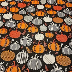 Halloween pumpkin variety on black background material by the yard and is 100% cotton