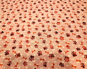 El estampado de huellas de perro sobre fondo rosa se vende a medida y es 100% algodón.