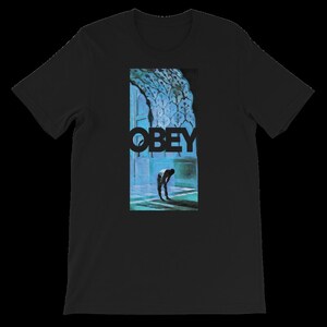 K&ouml;nnte beinhalten: Schwarzes T-Shirt mit einem blauen und wei&szlig;en Grafikdruck einer Person, die in einem Durchgang steht, mit dem Wort "OBEY" in Schwarz gedruckt.