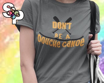 May include: Gray t-shirt with the text "DON'T BE A Douche Canoe" in yellow and black. The design includes crossed oars above the words. The shirt is a short-sleeved crew neck.