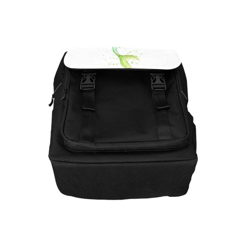 K&ouml;nnte beinhalten: Ein schwarzer Rucksack mit einer wei&szlig;en Klappe, die eine gr&uuml;ne Aquarell-Illustration einer Meerjungfrauenflosse zeigt. Der Rucksack verf&uuml;gt &uuml;ber zwei schwarze Kunststoff-Schnallenverschl&uuml;sse auf der Vorderseite, ein Hauptfach mit Rei&szlig;verschluss und verstellbare schwarze Trageriemen.