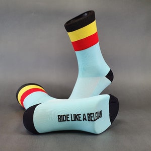 May include: A pair of light blue cycling socks with black, yellow and red stripes on the top. The socks have the text "Ride Like a Belgian" printed on the side.