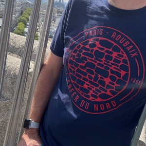 May include: A navy blue t-shirt with a red circle graphic featuring the text "Paris-Roubaix 1896 Enfer du Nord".