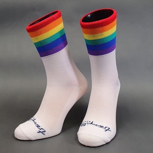 May include: A pair of white athletic socks with a rainbow stripe design. The socks are made of a breathable material and have a mesh pattern.