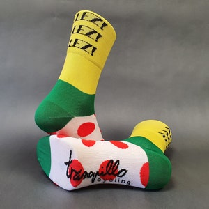 May include: A pair of white, green and yellow cycling socks with red polka dots. The socks have the text "Allez!" on the yellow portion and "Tranquillo Cycling" on the white portion.