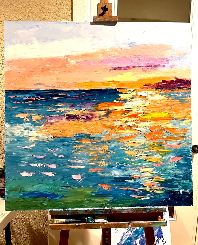 May include: Abstract painting of a seascape with a sunset sky in shades of pink, orange, and yellow. The water is painted in shades of blue, green, and white, with thick brushstrokes creating a textured effect.