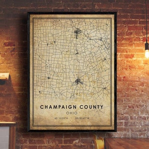 May include: A vintage-style map of Champaign County, Ohio, with black lines on a beige background. The map shows roads and towns. The text "Champaign County, Ohio" is printed in black at the bottom of the map, along with the coordinates "40.1028°N 83.8049°W".