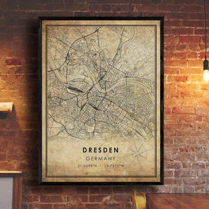 May include: A vintage style map print of Dresden, Germany. The map is in black and white with a beige background. The city name and coordinates are printed at the bottom of the map. "Dresden, Germany 51.0504°N 13.7373°W"