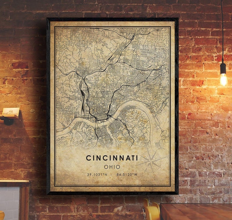 May include: A vintage-style map print of Cincinnati, Ohio. The map is in black and white with a beige background. The city name and coordinates are printed at the bottom of the map.