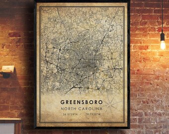 May include: A vintage-style map print of Greensboro, North Carolina. The map is in black and white with a beige background. The city name and coordinates are printed at the bottom of the map.