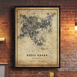 May include: A vintage-style map of Addis Ababa, Ethiopia, with a compass rose and the coordinates 8.9806°N 38.7578°E. The map is printed on a beige background with black lines and text.