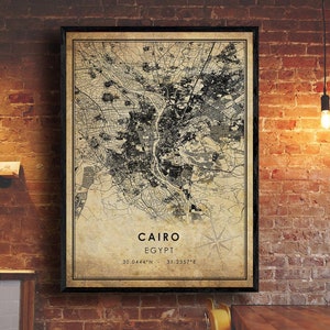 May include: A vintage-style map print of Cairo, Egypt. The map is in black and white with a beige background. The city name and coordinates are printed at the bottom of the map.