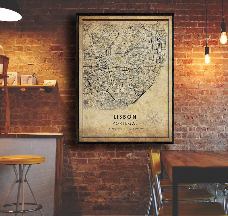 May include: A vintage-style map print of Lisbon, Portugal, with a black frame. The map shows the city's streets and landmarks. The text "LISBON PORTUGAL 38.7223&deg;N 9.1393&deg;W" is printed at the bottom of the map.