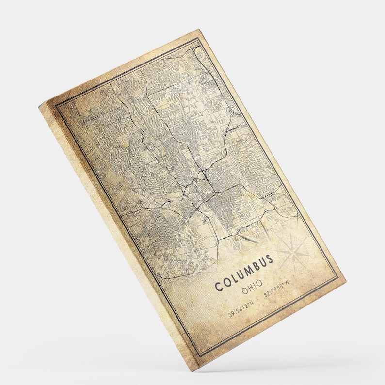 May include: Vintage style map print of Columbus, Ohio with a distressed background. The map shows the city streets and landmarks. The text "Columbus, Ohio" is printed at the bottom of the map along with the coordinates "39.9612&deg;N - 82.9988&deg;W".