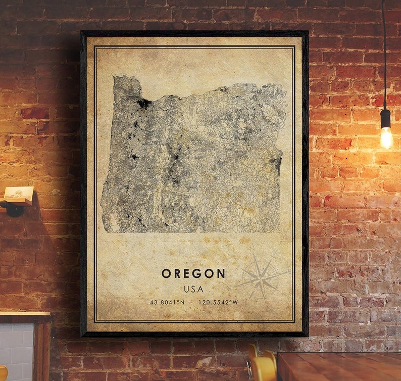 Puede incluir: Mapa enmarcado de Oreg&oacute;n, EE. UU., de estilo vintage, con coordenadas y rosa de los vientos. El mapa es en tonos grises y beige, sobre un marco oscuro. El fondo es una pared de ladrillo.
