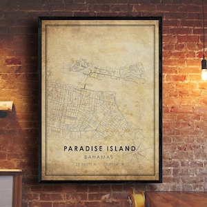 May include: A vintage-style map print of Paradise Island in the Bahamas. The map shows the island's streets and landmarks in black and white on a beige background. The text "PARADISE ISLAND" and "BAHAMAS" is printed in black at the bottom of the map, along with the coordinates "25.0821° N - 77.3134° W".