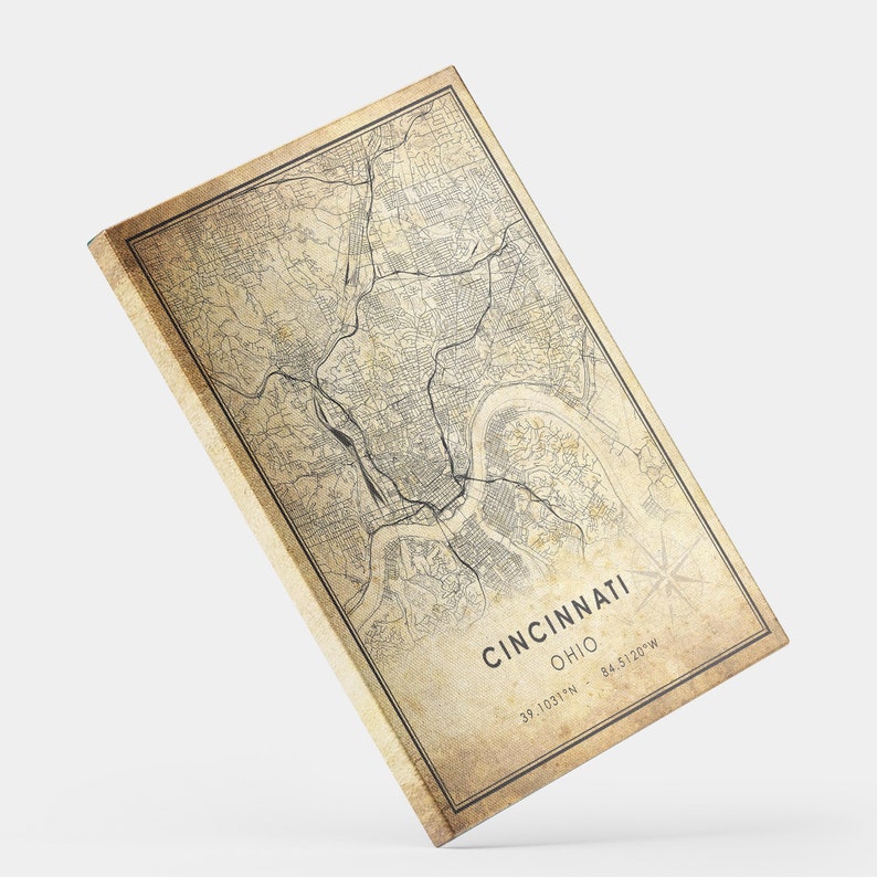 May include: Vintage style map print of Cincinnati, Ohio with a beige background and black lines. The text "Cincinnati, Ohio" is printed in black at the bottom of the map. The coordinates "39.1031&deg;N - 84.5120&deg;W" are printed in black below the city and state name.