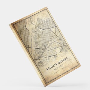 May include: A vintage-style map of Astoria, Queens, New York City. The map is printed on a textured, cream-colored background with black lines and text. The text at the bottom reads "Astoria Queens, New York, 40.7644&deg;N - 73.9235&deg;W".