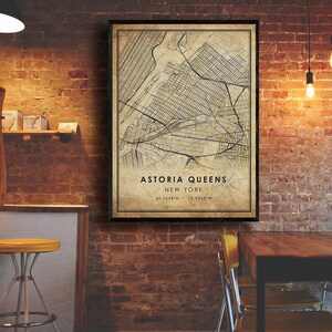 May include: A vintage-style map print of Astoria, Queens, New York City. The map is printed on a beige background with black lines and text. The text at the bottom reads "Astoria Queens, New York, 40.7644&deg;N, 73.9235&deg;W".